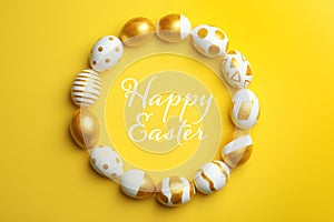 Frame made of traditional Easter eggs decorated with golden paint on color background, top view