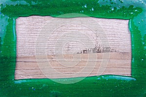 Frame made from transparent green slime on a wooden table