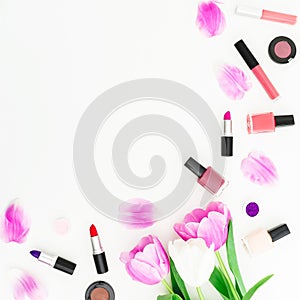 Frame made of tulips flowers and cosmetics on white background. Top view. Flat lay. Beauty feminine desk composition.