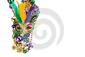 Frame of Mardi Gras mask and beads isolated on white background.