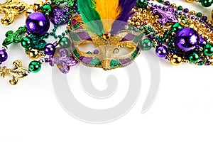 Frame of Mardi Gras mask and beads isolated on white background.
