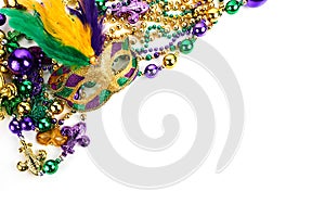 Frame of Mardi Gras mask and beads isolated on white background.