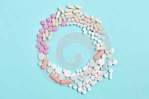 the frame of medicines in the form of tablets and capsules, different shapes on a blue background.