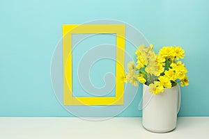 Frame mockup. Blank frame with yellow flowers in vase photo