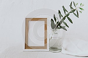 Frame mockup, olive branch in glass bottle, pitcher, styled minimalist clean image