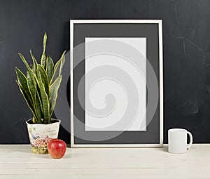 Frame mockup with plant pot, apple and mug