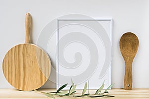 Frame mockup, wood cutting board, spoon, olive tree branch on white background, styled image photo