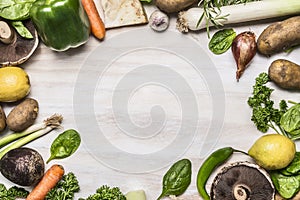 Frame of mushrooms onion potato greens lemon pepper garlic on white rustic wooden background top view