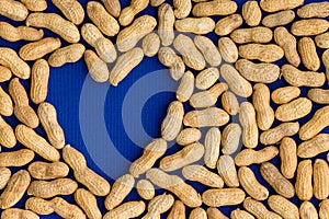 Frame of natural peanuts around a blue heart