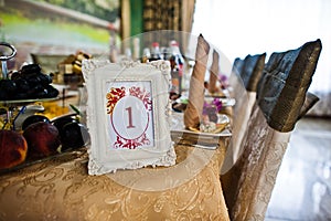 Frame with number one at table of guest on wedding restaurant.