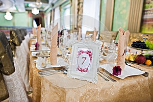 Frame with number seven at table of guest on wedding restaurant.