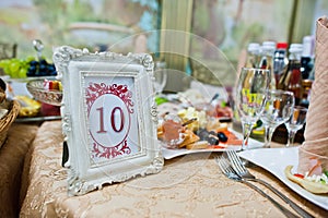 Frame with number ten at table of guest on wedding restaurant.