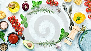 Frame of organic food. Fresh raw vegetables with spices, basil and rosemary on a gray stone background.