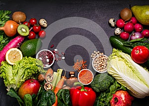 Frame of organic foods on a black background. Fresh vegetables, fruits,cereals and legumes.Vegan and vegetarian concept.Top view,