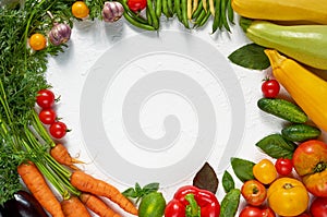 Frame of organic raw vegetables, herbs and spices on the white table. Healthy vegetarian diet food background. Top view