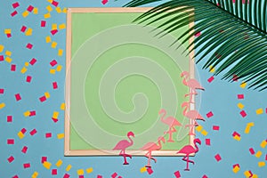 frame with pastel green background as copy space, on the background and pink flamingos