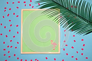 frame with pastel green background as copy space, on the background and pink flamingos around