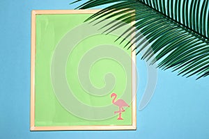 frame with pastel green background as copy space, on the background and pink flamingos, next to the