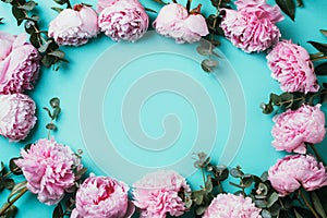 Frame pattern of pink peonies, eucalyptus flowers on pastel blue background. Flat lay, top view. Floral composition. Wedding,