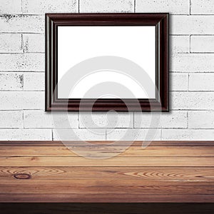 Frame picture on white brick wall and wood table background