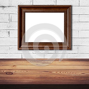Frame picture on white brick wall and wood table background