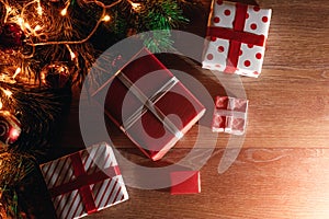 A frame of pine branches and Christmas decorations and gifts on a wooden table. Holidays christmas background. Copy space for text