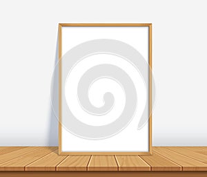 Frame with poster mockup standing on the wooden table