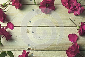Frame of red roses wooden background