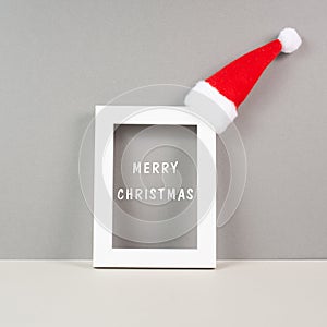 Frame with red Santa Claus hat, winter greeting card, merry christmas