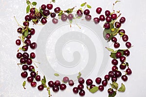Frame of ripe red cherries on the textured gray background with copy space
