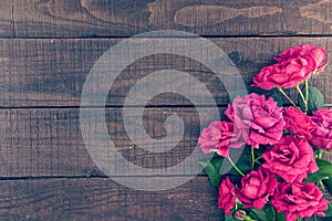 Frame of roses on dark rustic wooden background. Spring flowers.