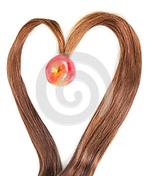 Frame in shape heart strands hair with apple inside isolated.