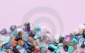 Frame in the shape of a wave of semi-precious minerals on a pink background. Healing crystals