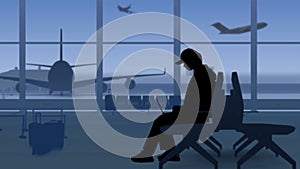 The frame shows an airport with a waiting room. A woman sits in silhouette in her hands she has a laptop, she is typing