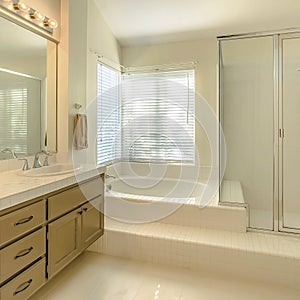 Frame Square Bathtub and double vanity unit inside the well lighted bathroom of a home