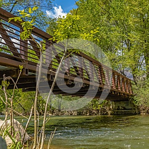 Frame Square Bridge with metal guardrails over the glistening water at Ogden River Parkway