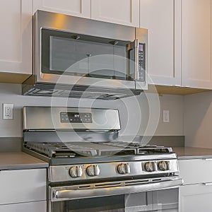 Frame Square Cooking range and wall mounted microwave inside a modern kitchen