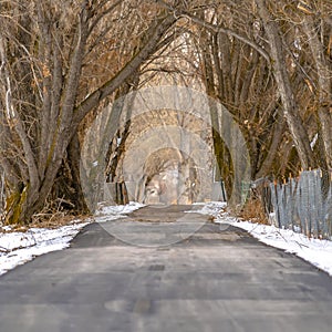 Frame Square Paved road with chain link and barbed wire fence amid a snow covered terrain