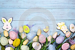 Frame of Sweets for celebrate Easter. Gingerbread in shape of easter bunny, chicken, colorful eggs and tulips