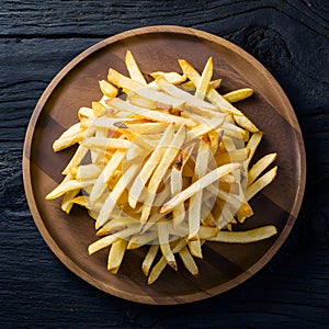Frame Tempting french fries elegantly presented on a wooden plate
