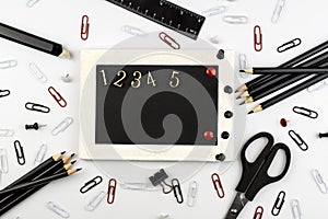 Frame for text with numbers, black school supplies lie on a white background