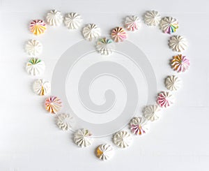 Frame for text in the shape of a heart from meringue. Frame for the design of meringues. Background with sweets