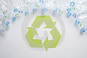 Frame of used plastic bottles with recycling symbol on wooden background. Recycle concept