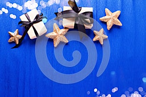 Frame from wrapped boxes with presents  and golden decorative stars on blue paper  textured  background.