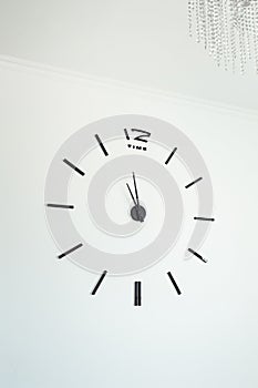 Frameless wall clock on white concrete wall. Minimalizm