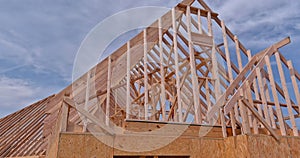 Framing beams of new home under construction wooden roof trusses