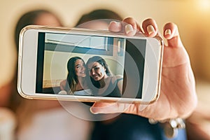 Framing their friendship. two attractive young women taking selfies in their local cafe.