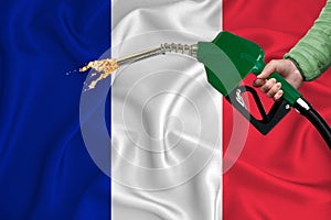 FRANCE flag Close-up shot on waving background texture with Fuel pump nozzle in hand. The concept of design solutions. 3d