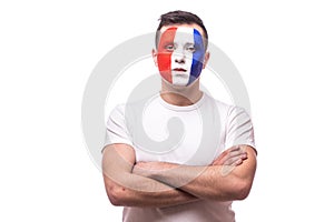 France football fan confident without emotion with crossed hands of France national football team on white background.