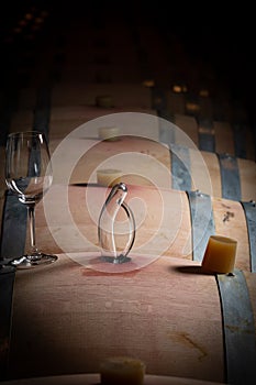 FRANCE, GIRONDE, SAINT-EMILION, SAMPLING A GLASS OF WINE IN A BARREL WITH A PIPETTE FOR TASTING AND VINIFICATION